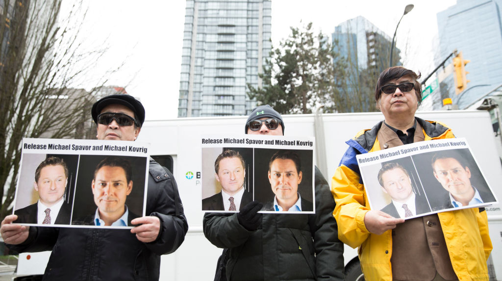 Manifestantes mantêm fotos dos canadenses Michael Spavor e Michael Kovrig, que foram detidos pelo regime chinês, do lado de fora da Suprema Corte da Colúmbia Britânica em Vancouver, enquanto a diretora financeira da Huawei, Meng Wanzhou, aparece no tribunal em 6 de março de 2019 (JASON REDMOND / AFP via Getty Images)