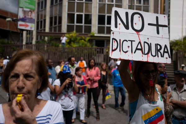 Uma mulher segura uma faixa que diz "Não mais ditadura" durante uma manifestação contra o regime de Nicolás Maduro convocada por Juan Guaidó em 30 de janeiro de 2019 em Caracas, Venezuela (Marco Bello / Getty Images)