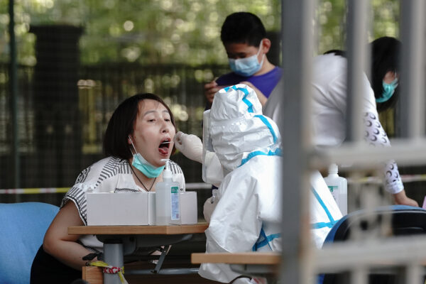 Um trabalhador médico tira um cotonete de uma residente em uma estação de testes COVID-19 em Pequim, China, em 30 de junho de 2020 (Lintao Zhang / Getty Images)