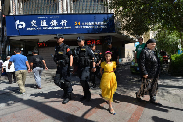A polícia armada chinesa patrulha as ruas do bairro muçulmano uigur em Urumqi, Xinjiang, China em 29 de junho de 2013 (MARK RALSTON / AFP via Getty Images)