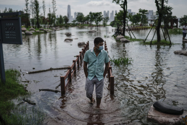 Um morador usa uma máscara facial enquanto caminha pelo Parque Jiangtan, que foi inundado devido a fortes chuvas ao longo do rio Yangtze em Wuhan, China, em 8 de julho de 2020 (Getty Images)