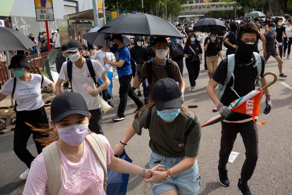 Os manifestantes correm depois de ouvir a polícia se aproximar durante uma manifestação contra uma nova lei de segurança nacional em Hong Kong em 1º de julho de 2020 (Alastair Pike / AFP via Getty Images)