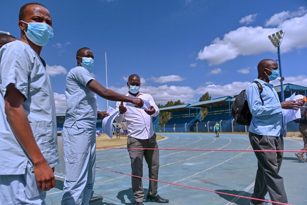 Folhas de dispensa manual de médicos junto com tiras de teste de laboratório indicando um resultado negativo para os pacientes que receberam alta após terem se recuperado da infecção por COVID-19 no Estádio Kenyatta na cidade oriental de Machakos do Quênia em 3 de agosto de 2020 (Tony Karumba / AFP via Getty Images)