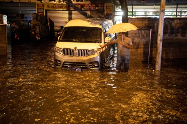 Um homem olha para uma rua inundada após uma chuva repentina em Pequim em 9 de agosto de 2020 (NOEL CELIS / AFP via Getty Images)