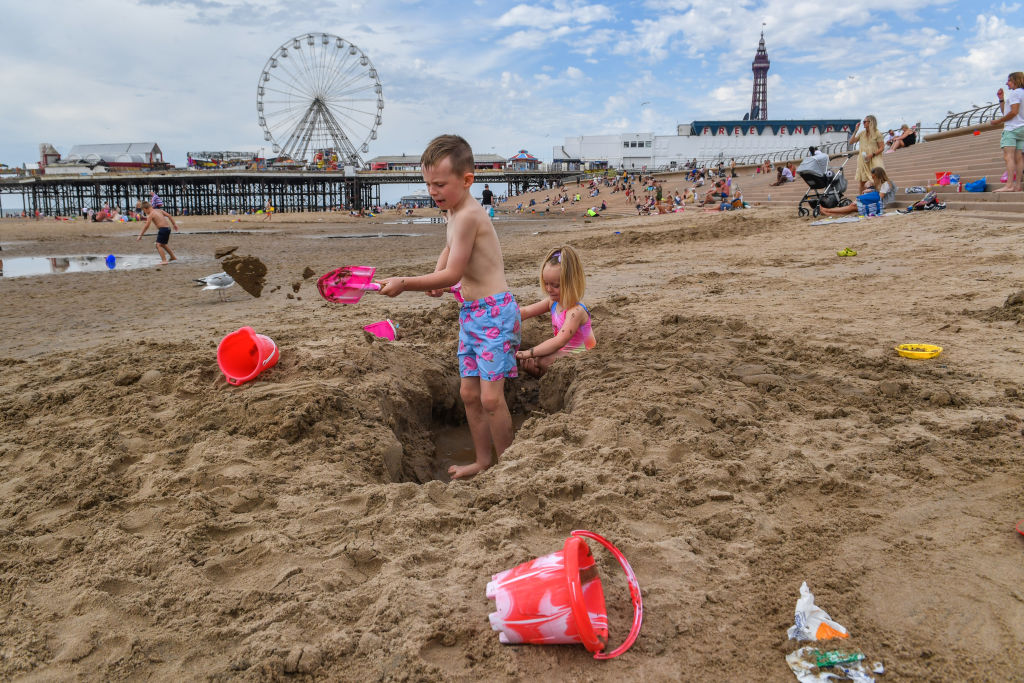 Crianças constroem castelos de areia na praia de Blackpool em Blackpool, Inglaterra, em 31 de julho de 2020 (Anthony Devlin / Getty Images)