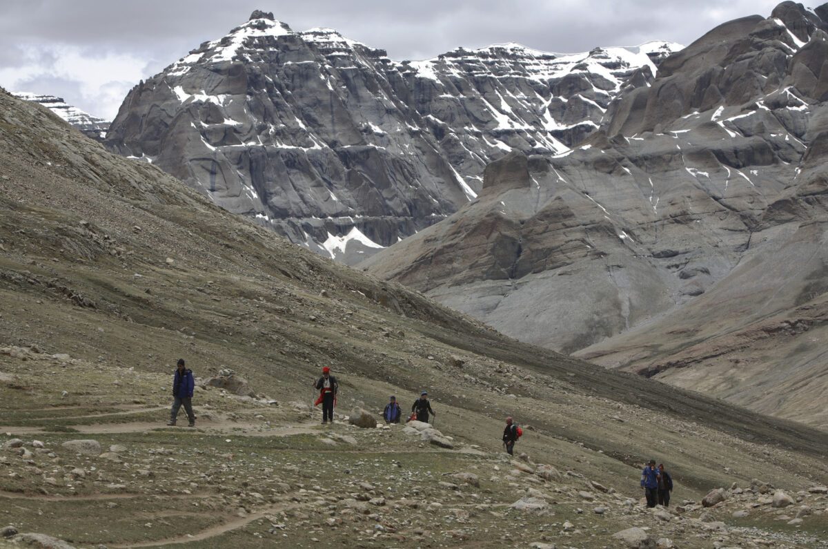 Adoradores religiosos caminham ao redor da montanha Kangrinboqe coberta de neve, conhecida como montanha Kailash no oeste, em 15 de junho de 2007 no condado de Purang da Região Autônoma do Tibete, China (Fotos da China / Getty Images)