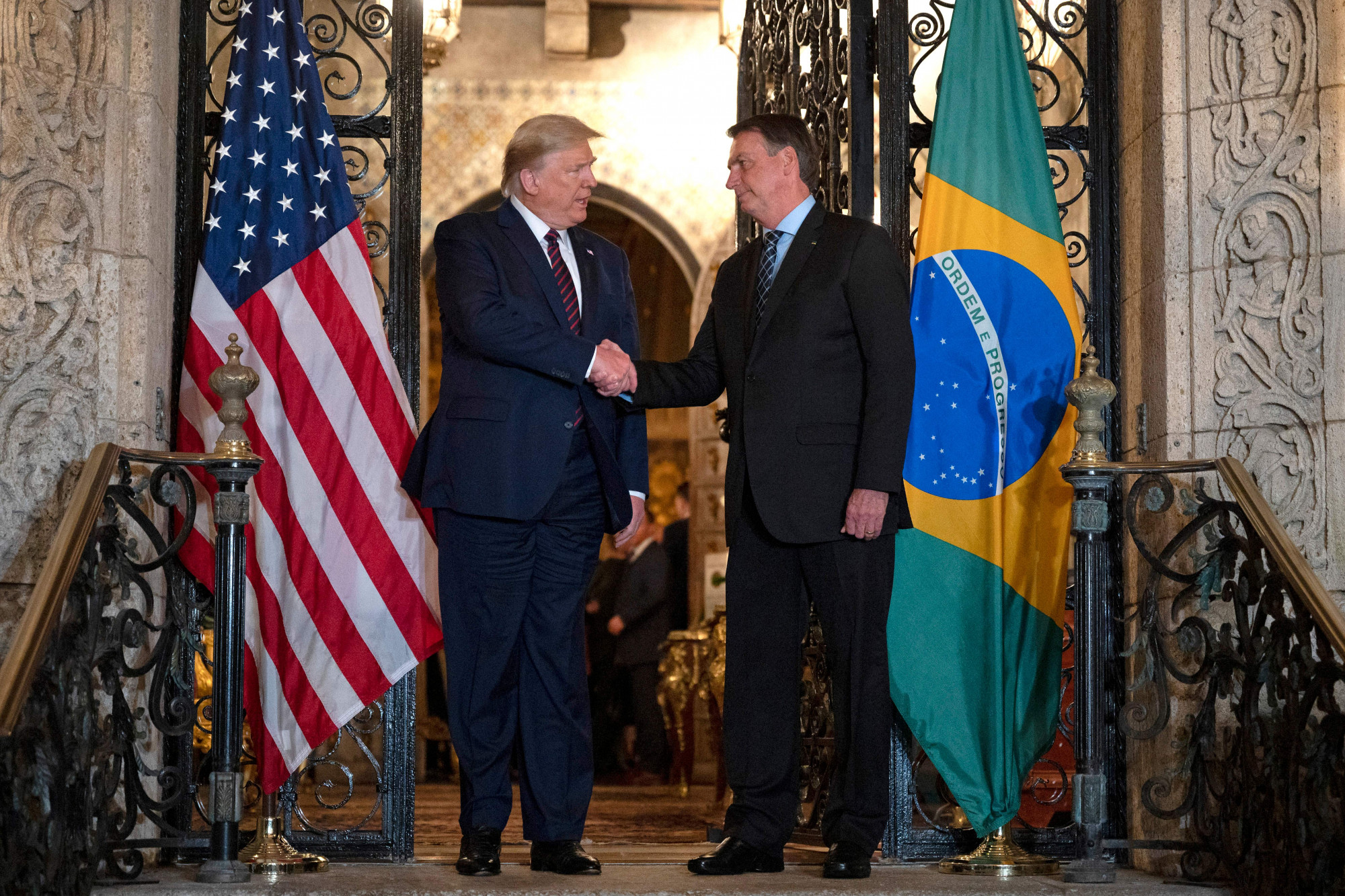 O presidente dos Estados Unidos, Donald Trump, cumprimenta o presidente brasileiro Jair Bolsonaro durante um jantar em Mar-a-Lago em Palm Beach, Flórida, em 7 de março de 2020 (JIM WATSON / AFP via Getty Imagens)