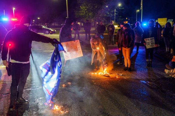 Manifestantes anti-Trump queimam as bandeiras da campanha de Trump em frente ao Aeroporto Duluth, 30 de setembro de 2020 (KEREM YUCEL / AFP via Getty Images)