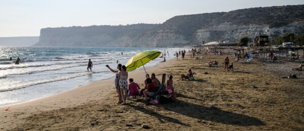 Turistas posam juntos para uma foto na praia mediterrânea de Kourion ao longo da Baía de Episkopi, a oeste de Limassol, no sudoeste de Chipre, em 25 de agosto de 2020 (AMIR MAKAR / AFP via Getty Images)