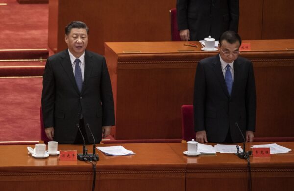 O líder chinês Xi Jinping (à esquerda) e o primeiro-ministro Li Keqiang cantam o hino nacional em uma cerimônia que marca o 70º aniversário da entrada da China na Guerra da Coréia, no Grande Salão do Povo, em Pequim, China, em 23 de outubro de 2020 (Kevin Frayer / Getty Images)