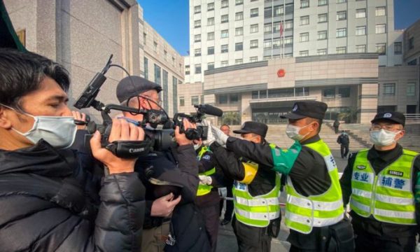 A polícia tenta impedir que jornalistas gravem imagens do lado de fora do Tribunal Popular do Novo Distrito de Pudong, em Xangai, China, em 28 de dezembro de 2020 (Leo Ramirez / AFP via Getty Images)