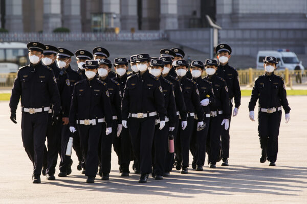 Policiais chineses mascarados marcham pela Praça Tiananmen em Pequim, China, em 4 de abril de 2020 (Lintao Zhang / Getty Images)