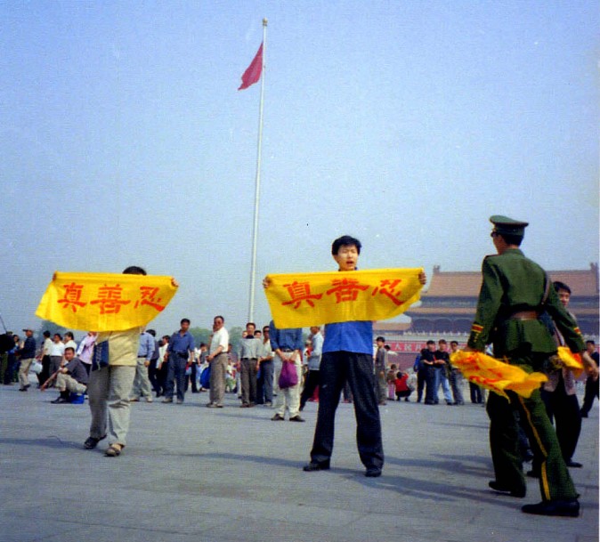 Policial chinês aborda praticantes do Falun Gong que viajaram pela China até a Praça Tiananmen para fazer apelos pacíficos contra a perseguição em 2001 (Cortesia de Minghui)
