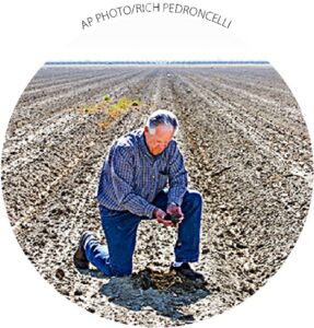 Mike Stearns, presidente da Autoridade de Água de San Luis e Delta-Mendota, verifica os níveis de umidade do solo perto de Firebaugh, Califórnia, em 25 de fevereiro. Stearns teve que pousar milhares de hectares devido aos cortes de água. 