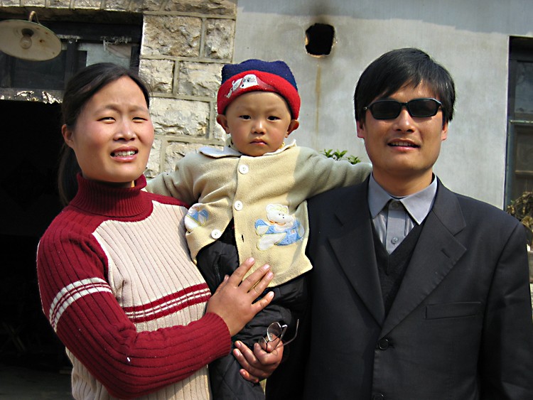 Uma foto datada de 28 de março de 2005 mostra o ativista cego Chen Guangcheng (D) com sua esposa e filho Chen Kerui fora de casa na vila de Dondshigu, província de Shandong no nordeste da China. Teng Biao ajudou a servir como advogado de Chen (STR/AFP/Imagens Getty)