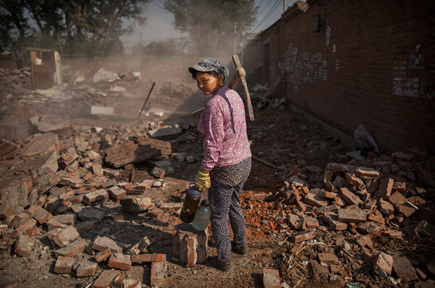 Um trabalhador chinês espera para ajudar a demolir uma casa na vila de Gucheng, distrito de Tongzhou, Pequim, em 15 de outubro de 2015 (Kevin Frayer/Getty Images)