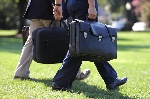 Um assistente militar carrega uma valise com os códigos nucleares enquanto acompanha o presidente Barack Obama no gramado da Casa Branca, em Washington, D.C., em 23 de agosto de 2016 (Chip Somodevilla/Getty Images)