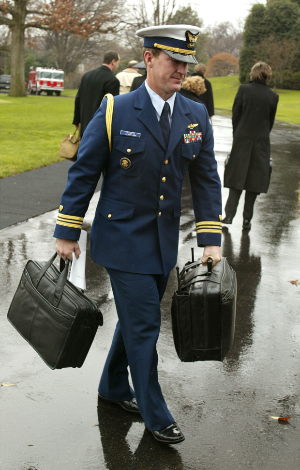 Um oficial militar dos Estados Unidos carrega uma valise com os códigos nucleares após retornar à Casa Branca com o presidente George W. Bush em 7 de janeiro de 2002 (Mark Wilson/Getty Images)