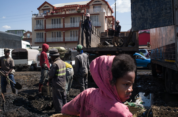 Funcionários de saúde eliminam o lixo durante a limpeza do mercado de Anosibe no distrito de Anosibe, um dos distritos mais insalubres de Antananarivo, Madagascar, em 10 de outubro de 2017 (Rijasolo/AFP/Getty Images)