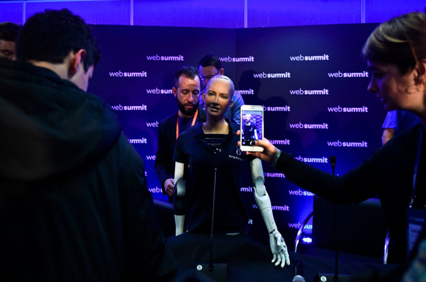 Uma mulher fotografa o robô humanoide "Sophia", fabricado pela Hanson Robotics, durante uma conferência de imprensa no evento "2017 Web Summit" em Lisboa em 7 de novembro de 2017 (Patricia de Melo Moreira/AFP/Getty Images)