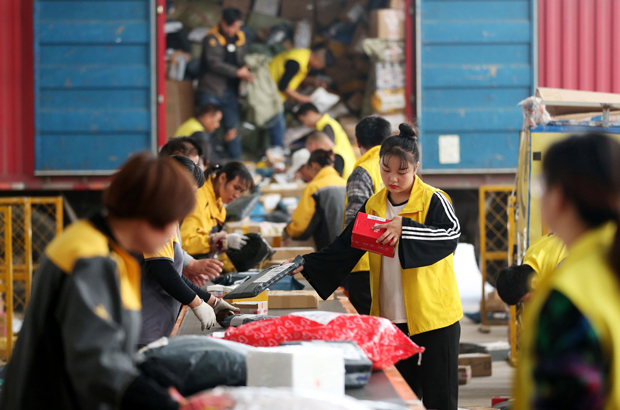 Empregados classificam pacotes antes do festival de compras online no Dia dos Solteiros, na cidade de Huaibei, província de Anhui, China, em 9 de novembro de 2017. (STR/AFP/Getty Images)