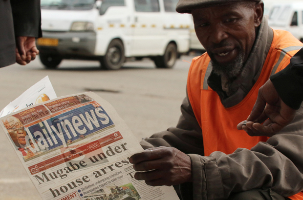 Um vendedor de rua lê um jornal no centro de Harare, no Zimbabwe, em 16 de novembro de 2017 (Reuters/Philimon Bulawayo)