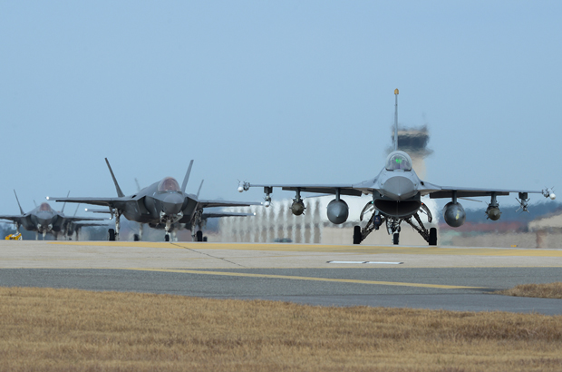 Coreia do Norte, ONU, paz - Um caça F-16 Falcon da Força Aérea dos EUA e quatro caças F-35A Lightning II manobram na pista durante o exercício Vigilant Ace 18 na Base Aérea de Kunsan, na Coreia do Sul, em 3 de dezembro de 2017 (Aviador Sênior Colby L. Hardin/Força Aérea dos EUA)