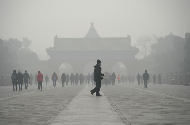 China, carvão, poluição, gás natural - Um idoso chinês anda diante de um grupo de pessoas sob uma densa névoa em Pequim em 20 de dezembro de 2016 (Wang Zhao/AFP/Getty Images)