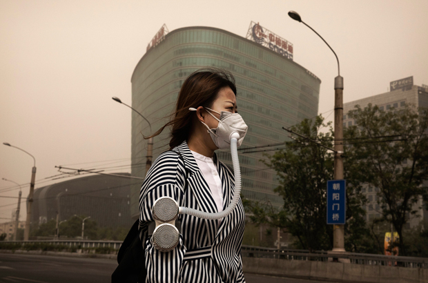 China, escassez, gás natural, poluição - Uma chinesa usa máscara para proteger-se contra uma tempestade de areia e poluição em Pequim em 4 de maio de 2017 (Kevin Frayer/Getty Images)