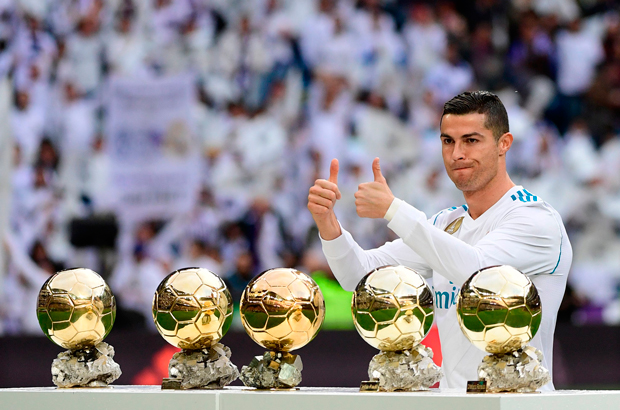 Portugal - O atacante português do Real Madrid, Cristiano Ronaldo, posa diante de suas cinco Bolas de Ouro antes de um jogo de futebol da liga espanhola entre o Real Madrid e o Sevilla no Estádio Santiago Bernabeu, em Madrid, em 9 de dezembro de 2017 (Pierre-Philippe Marcou/AFP/Getty Images)