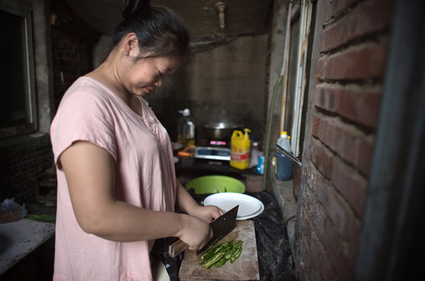 China, Partido Comunista Chinês, Xi Jinping, empresariado, pobreza - Uma chinesa prepara comida numa cozinha comum num bairro de imigrantes na periferia de Pequim em 7 de setembro de 2017 (Nicolas Asfouri/AFP/Getty Images)