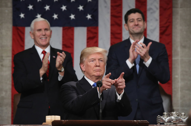 Estados Unidos, Donald Trump, economia, Dow Jones, bolsa de valores, mercado de ações - O presidente norte-americano Donald Trump sinaliza durante seu discurso do Estado da União, enquanto o vice-presidente Mike Pense (esq.) e o presidente da Câmara, Paul Ryan (R-WI) (dir.), aplaudem, na Câmara dos Representantes no Capitólio em Washington, D.C., em 30 de janeiro de 2018 (Win McNamee/Getty Images)